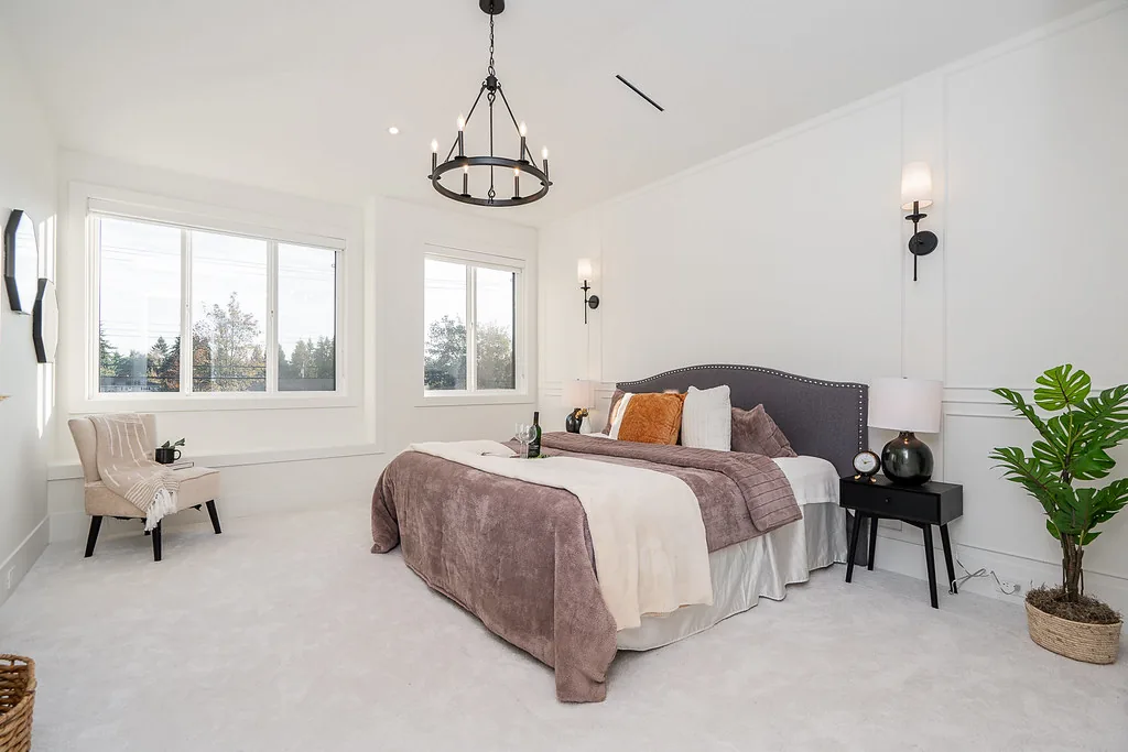 Primary bedroom with chandelier and large window