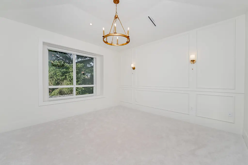 Bedroom with wall panelling and brass chandelier